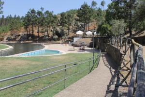 a fence next to a pool in a park at Sky carvoeiro in Mação
