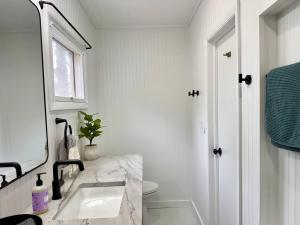 a bathroom with a sink and a toilet and a window at Cayuga lake cottage with private lake access in Washingtonville +20 photos