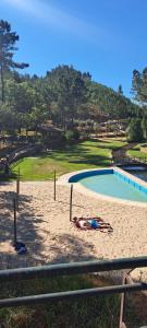 a woman laying on the beach next to a swimming pool at Sky carvoeiro in Mação