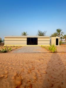 a building sitting on top of a dirt road at Remal Inn Bidiyah in Badīyah