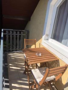 a wooden table and chair on a balcony at Tekergő Vendégház in Balatonfüred