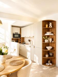 a kitchen with a wooden table and white cabinets at Charming house with rooftop - Gassin in Gassin +13 photos