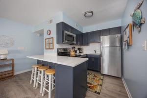 a kitchen with a stainless steel refrigerator and stools at 2973 - The Shack in Duck +27 photos