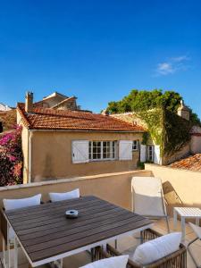 a patio with a wooden table and chairs on a balcony at Charming house with rooftop - Gassin in Gassin