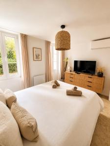 a bedroom with a large white bed and a tv at Charming house with rooftop - Gassin in Gassin
