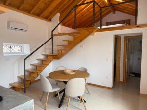 a dining room with a wooden table and stairs at Solar dos Caseiros in Macieiro da Maia