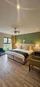 a bedroom with a large bed and a ceiling at Magellans Hotel in Simonʼs Town