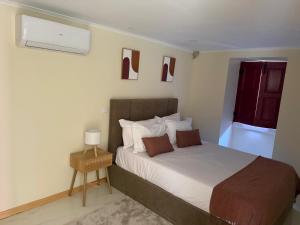 a bedroom with a large bed with a nightstand and a window at Solar dos Caseiros in Macieiro da Maia +43 photos