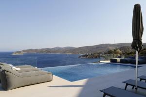 a villa with a pool with a view of the ocean at PETRA Luxury Villas in Agioi Apostoli