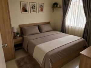 a bedroom with a bed and a window at โฮมสเตย์วารังสิริ 1 in Ban Wat Tha Maprang