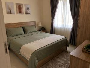 a bedroom with a large bed and a window at โฮมสเตย์วารังสิริ 1 in Ban Wat Tha Maprang