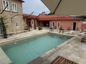 a swimming pool in front of a house at Solar dos Caseiros in Macieiro da Maia