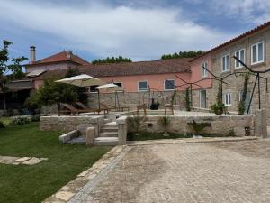 a house with two umbrellas and a patio at Solar dos Caseiros in Macieiro da Maia