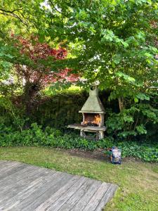 a small fireplace in a garden next to a tree at Magnolia in Wuustwezel