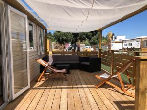 a wooden deck with a couch and a white canopy at Beach Break Bungalows Playa El Palmar in Cádiz +9 photos
