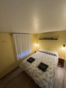 a bedroom with a bed with two towels on it at Beach Break Bungalows Playa El Palmar in Cádiz