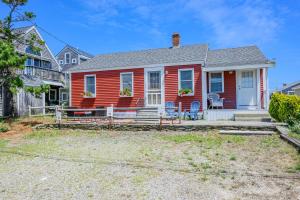 a red house with chairs in front of it at East Sandwich Beachfront Retreat in East Sandwich