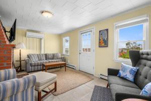 a living room with a couch and chairs and a table at East Sandwich Beachfront Retreat in East Sandwich