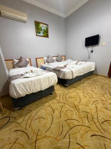 two beds in a room with a tv on the wall at Grand Bazaar Hotel Merve in Istanbul