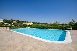 a large swimming pool in a yard with a house at MGH Luxury - Villa Panorama in Bardolino