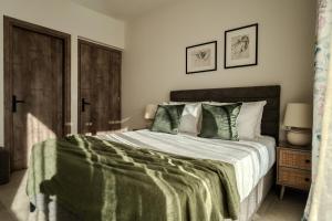 a bedroom with a large bed with a green blanket at AnaRose Zante Villa-by Sakis and Sam in Planos