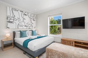 a bedroom with a bed and a flat screen tv at Sangrove Residence in Cape Town