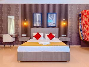 a bedroom with a large bed with red pillows at Pearl Beach Resort in Covelong