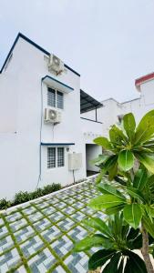 a white house with a plant in front of it at Pearl Beach Resort in Covelong