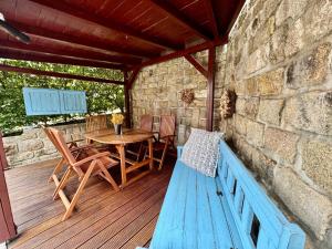a wooden deck with a table and chairs and a bench at Apartmán v Dráze in Zásada