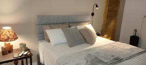a bedroom with a bed and a table with a lamp at Suíte Arvoredo in Saquarema +17 photos