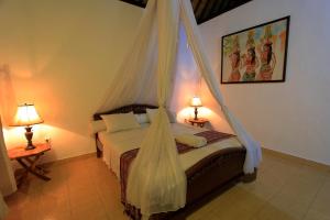 a bedroom with a bed with a mosquito net at Alamanda Bingin in Uluwatu