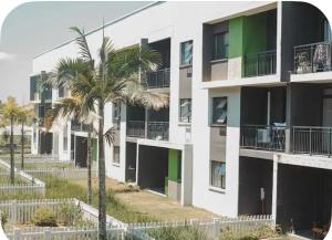 an apartment building with palm trees in front of it at Ballito Seasons in Ballito