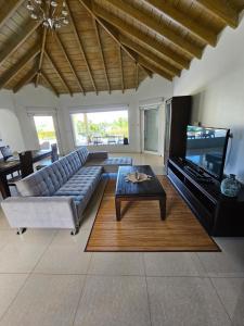 a living room with a couch and a flat screen tv at C'RENITY VILLA in Cul de Sac