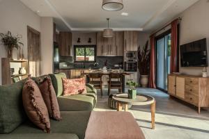 a living room with a green couch and a kitchen at AnaRose Zante Villa-by Sakis and Sam in Planos