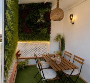 a patio with a table and chairs and a green wall at Casa Laura y Pancho in Fasnia