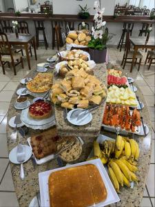 a table with many different types of food on it at Hotel Itajaí Tur - Itajaí Navegantes in Itajaí