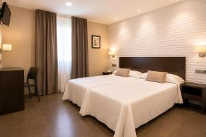 a hotel room with a large white bed and a window at Hotel Restaurante El Corte in Casabermeja +31 photos