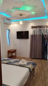 a room with a bed and a flat screen tv at Hostal Fragata Puerto López in Puerto López