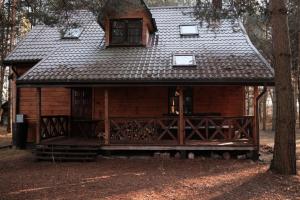eine kleine Blockhütte mit Veranda und Fenstern in der Unterkunft Marusia in Wajków