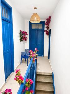 a hallway with blue doors and flowers on the stairs at Casa Mykonos Rio in Rio de Janeiro +24 photos