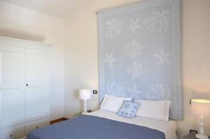a bedroom with a blue wall and a bed at Sa Tirìa in Chia