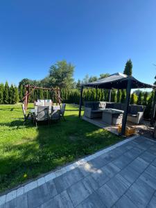a backyard with a gazebo and a table and chairs at zakątek pod świerkami in Gulbiny