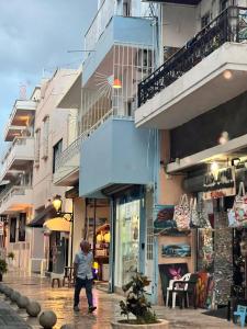 a woman walking down a street next to a building at A Night at Zona colonial in Santo Domingo