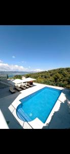 a large blue swimming pool with a view of the ocean at My place Čiovo holiday house in Žedno