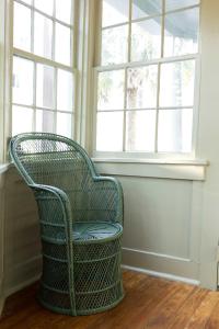 a wicker chair sitting in front of a window at The Nicholas Veranda King Suite - Steps to King in Charleston +21 photos
