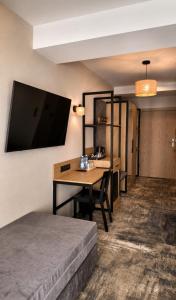 a hotel room with a desk and a bed at Zacisze Nad Nidą Resort in Pińczów