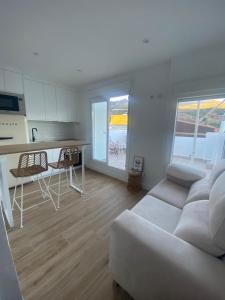 a living room with a white couch and a kitchen at El Palomar in El Arenal