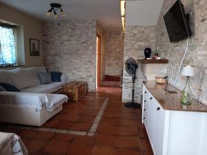 a living room with a white couch and a brick wall at Casa Rural Juaco in Bimenes