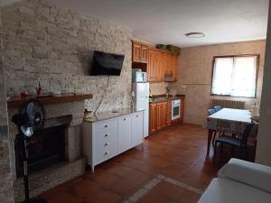a kitchen with a fireplace and a table in it at Casa Rural Juaco in Bimenes