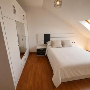 a bedroom with a large white bed and a mirror at El Burgo Eclipse Retreat in El Burgo de Osma